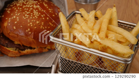 Serving a fast menu of beef burger and french fries in a special basket Serving a fast menu of beef burger and french fries in a special basket 129290290