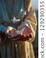 A person is holding three paper birds in their hands 129290355