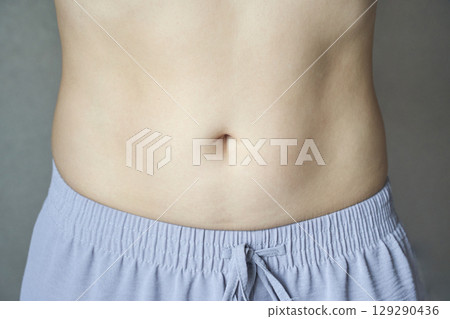 close up of young caucasian female bare midsection in relaxed pose wearing close up of young caucasian female bare midsection in relaxed pose wearing 129290436