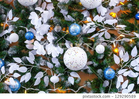 Christmas bauble with green fir branches, white leaves and illuminated Christmas bauble with green fir branches, white leaves and illuminated 129290589