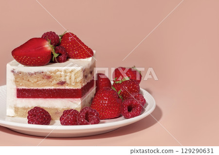 Layered bento cake featuring raspberry and strawberry toppings, showcasing vanilla sponge cake with vibrant colors, perfect for dessert and pastry menu concepts with delightful presentation 129290631