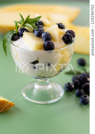 Dessert parfait of yogurt melon and blueberries on a green background Dessert parfait of yogurt melon and blueberries on a green background 129290702