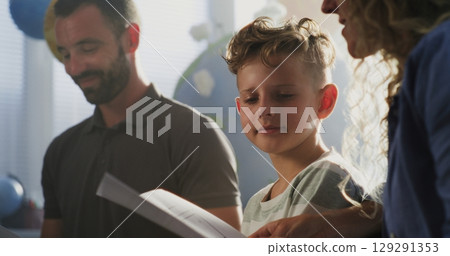 Mother and Father Looking at School Test Results of Their Son, Happy About Excellent Academic Performance Mother and Father Looking at School Test Results of Their Son, Happy About Excellent Academic Performance 129291353