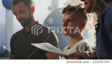 Mother and Father Looking at School Test Results of Their Son, Happy About Excellent Academic Performance Mother and Father Looking at School Test Results of Their Son, Happy About Excellent Academic Performance 129291354