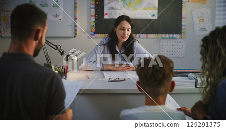 Female Teacher Discussing Academic Progress and Grades of Primary School Student with His Parents Female Teacher Discussing Academic Progress and Grades of Primary School Student with His Parents 129291375