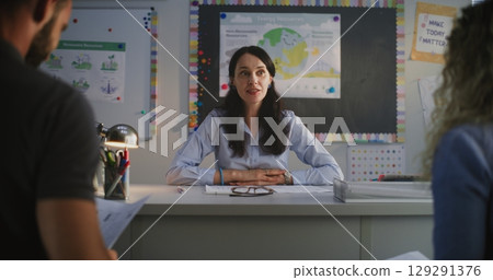 Female Teacher Discussing Academic Progress and Grades of Pupil with His Parents 129291376