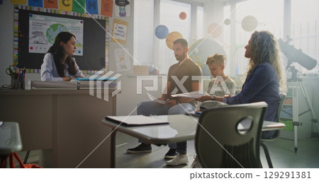 Teacher and Parents Discussing Academic Failure of Young Boy During Meeting 129291381