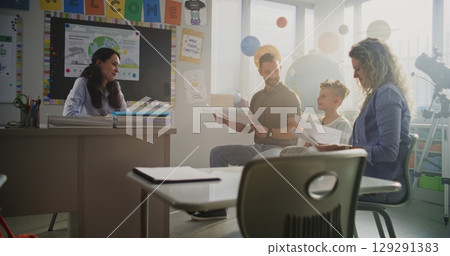 Mother and Father Looking at School Test Results of Their Son, Happy About Excellent Academic Performance Mother and Father Looking at School Test Results of Their Son, Happy About Excellent Academic Performance 129291383