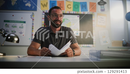 Male Teacher Presenting School Test Results to Student, Praising Young Boy for High Grades 129291413