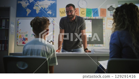 Male Teacher Giving School Exam Results of Student to His Mother, Praising Young Boy for High Grades Male Teacher Giving School Exam Results of Student to His Mother, Praising Young Boy for High Grades 129291416