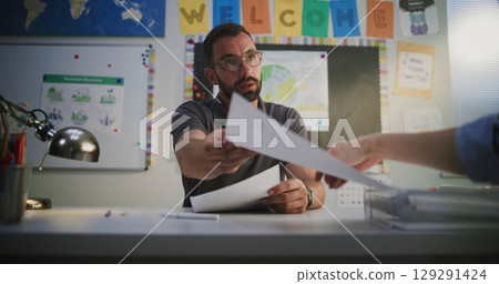Male Teacher Discussing Low Academic Grades of Primary School Student with His Mother Male Teacher Discussing Low Academic Grades of Primary School Student with His Mother 129291424