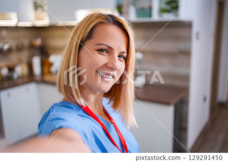 Female Doctor taking a selfie at home smiling at camera Female Doctor taking a selfie at home smiling at camera 129291450
