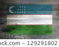 Uzbekistan flag on rustic old wood surface background 129291802