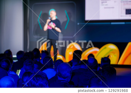 Speaker engaging audience during a modern presentation in a vibrant venue 129291988