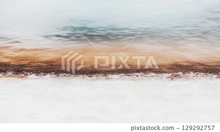 Coastal shoreline with sandy beach and calm water at sunrise in a serene natural landscape 129292757