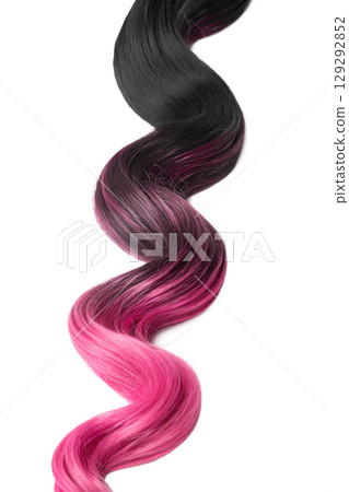 Ombre hair strand fading from black to pink, wavy balayage sample isolated, vivid color transition 129292852