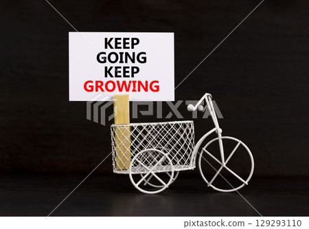 Keep going and growing symbol. Concept words phrase Keep going keep growing on beautiful white paper on clothespin. Beautiful black paper background. Business Keep going growing concept. Copy space. Keep going and growing symbol. Concept words phrase Keep going keep growing on beautiful white paper on clothespin. Beautiful black paper background. Business Keep going growing concept. Copy space. 129293110