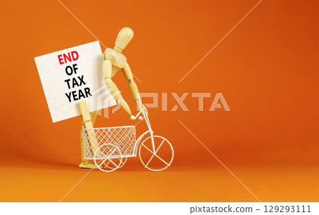 End of tax year symbol. Concept words phrase End of tax year on beautiful white paper on wooden clothespin. Bicycle. Beautiful orange paper background. Business End of tax year concept. Copy space. 129293111