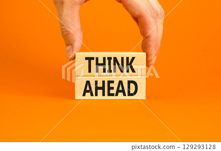 Think ahead symbol. Concept words Think ahead on wooden blocks on beautiful orange table orange background. Businessman hand. Business support motivation psychological think ahead concept. Copy space 129293128