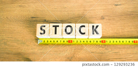 Stock symbol. Concept word Stock on beautiful wooden blocks. Beautiful wooden table wooden background. Beautiful yellow ruler. Business lifestyle stock concept. Copy space. 129293236