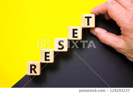 Reset symbol. Concept word Reset on beautiful wooden blocks. Beautiful yellow and black background. Businessman hand. Business lifestyle reset concept. Copy space. 129293237