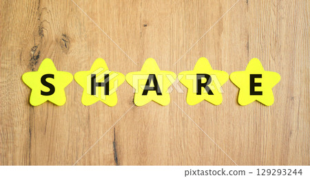Share symbol. Concept word Share on beautiful yellow paper stars. Beautiful wooden table wooden background. Business lifestyle share concept. Copy space. 129293244