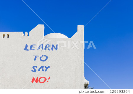 Learn to say no symbol. Concept words phrase Learn to say no on beautiful white wall. Beautiful white wall and blue sky background. Business psychological Learn to say no concept. Copy space. 129293264