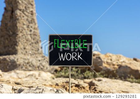 Flexible work symbol. Concept words Flexible work on beautiful yellow blackboard. Beautiful red stone beach blue sky background. Business Flexible work concept. Copy space. Flexible work symbol. Concept words Flexible work on beautiful yellow blackboard. Beautiful red stone beach blue sky background. Business Flexible work concept. Copy space. 129293281