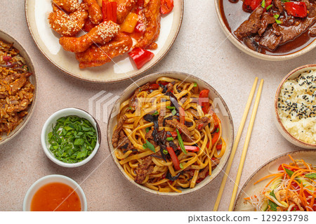 Variety of Chinese food dishes top view on table with chopsticks, light beige background, cuisine of China Variety of Chinese food dishes top view on table with chopsticks, light beige background, cuisine of China 129293798