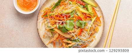 Delicious asian salad with rice noodles, chicken and vegetables, a healthy meal in oriental style Delicious asian salad with rice noodles, chicken and vegetables, a healthy meal in oriental style 129293809