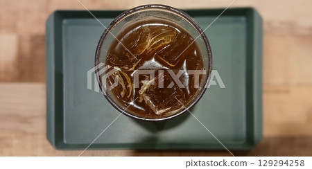 Top View of Iced Coffee in a Plastic Cup on a Wooden Table 129294258