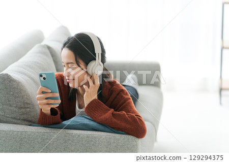 聽到與耳機的音樂的一個少婦 聽到與耳機的音樂的一個少婦 129294375