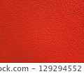 A bright background, a roughly plastered wall painted red. 129294552