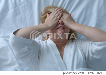 do peek-a-boo with your hands lie on the bed. cover your eyes with your palms, squint, play hide and seek 129294699