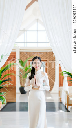 A beautiful traditionally dressed woman greets guests at the hotel reception A beautiful traditionally dressed woman greets guests at the hotel reception 129295111
