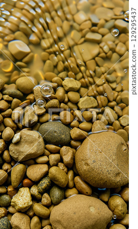Wet pebbles on the beach 129295437
