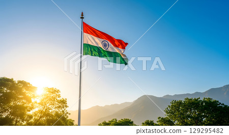 A vibrant flag of India flying proudly against a clear blue sky, with a mountain range at sunrise A vibrant flag of India flying proudly against a clear blue sky, with a mountain range at sunrise 129295482