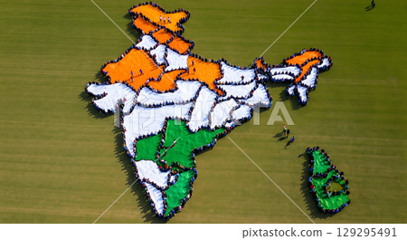 A massive group of people gathered in the shape of the map of India and Sri Lanka on a green field 129295491