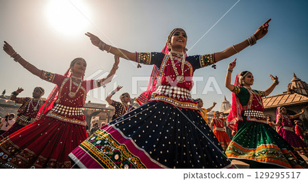 A group of joyful young women in traditional, colorful attire perform a vibrant folk dance with graceful, outstretched arms under a bright sky A group of joyful young women in traditional, colorful attire perform a vibrant folk dance with graceful, outstretched arms under a bright sky 129295517