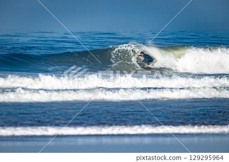 Surfer riding waves in Furadouro Beach Surfer riding waves in Furadouro Beach 129295964