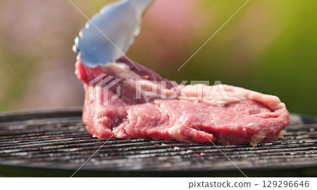 cook put fresh raw beef steak on charcoal grill 129296646