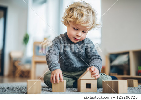 Joyful Child Engaged in Play with Wooden Toys on Soft Carpet in Bright Indoor Environment 129296723