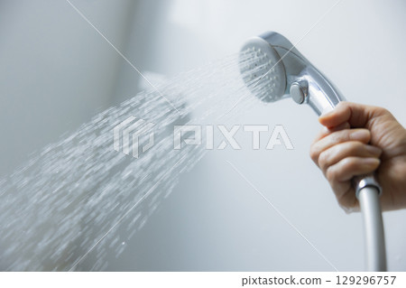 Woman's hand holding a shower head Woman's hand holding a shower head 129296757