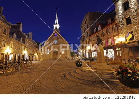 Tourists enjoying walking in Old Quebec streets, including Quebecois Fresco and Notre Dame des Victories church in Place Royale Tourists enjoying walking in Old Quebec streets, including Quebecois Fresco and Notre Dame des Victories church in Place Royale 129296813