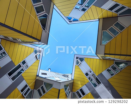 A star-like frame of yellow cube-shaped buildings against a blue sky. Cube Houses in Rotterdam, Netherlands. Kubuswoningen, designed by Piet Blom 129298202