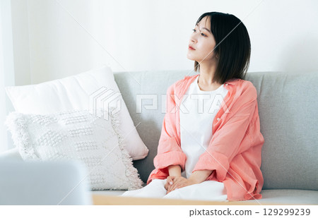 Young woman thinking in the living room Young woman thinking in the living room 129299239