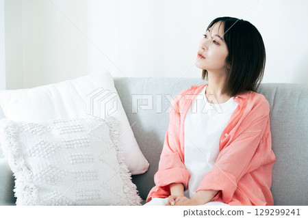 Young woman thinking in the living room Young woman thinking in the living room 129299241