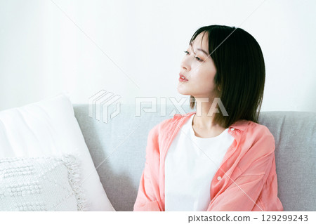 Young woman thinking in the living room Young woman thinking in the living room 129299243