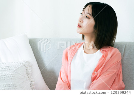 Young woman thinking in the living room Young woman thinking in the living room 129299244