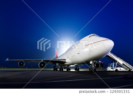 The plane stands at the airport at night The plane stands at the airport at night 129301331